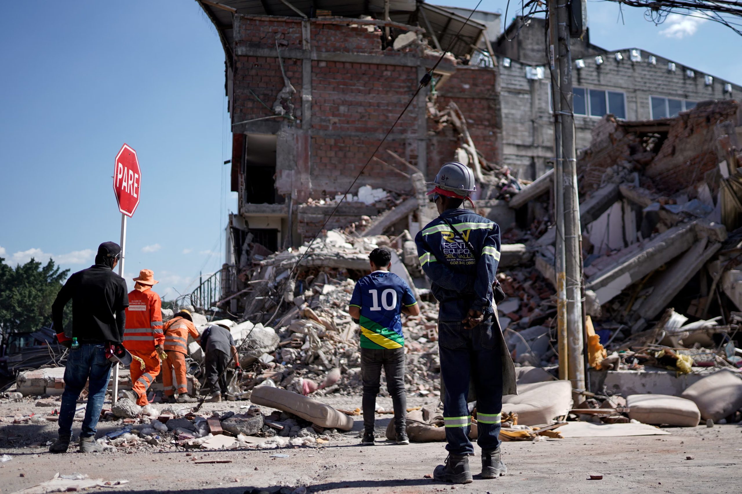Varias personas retiran escombros en el lugar donde se ha derrumbado un edificio tras un terremoto, en Cali (Colombia), el 11 de agosto de 2026. REUTERS/Sergio Acero