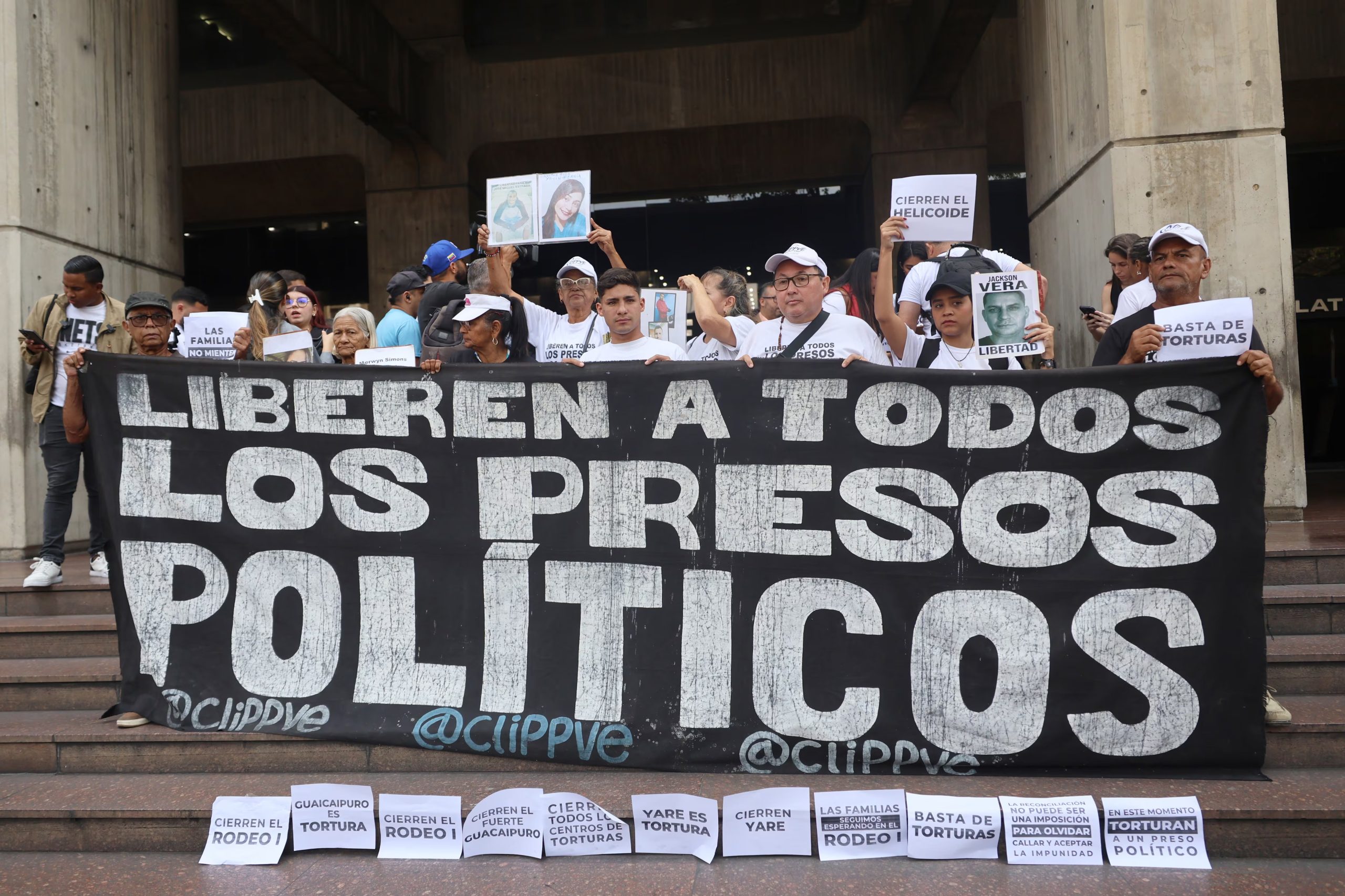 Un grupo de personas sostienen un cartel y varios avisos que piden la liberación de todos los presos políticos en Venezuela (EFE/Miguel Gutiérrez/Archivo)