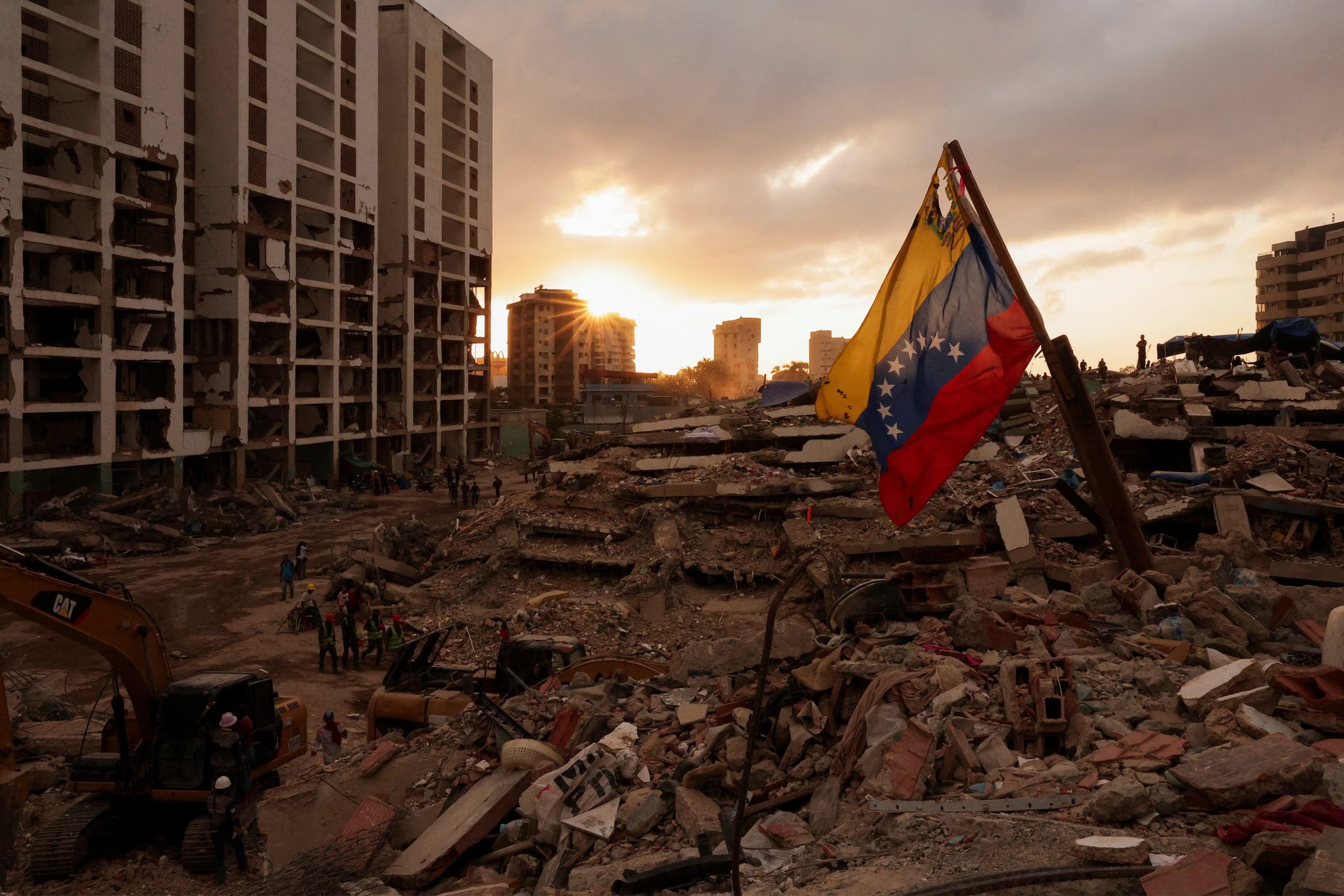 Una bandera venezolana ondea mientras la gente busca los cuerpos de sus seres queridos entre los escombros, tras los terremotos que sacudieron Venezuela, el 29 de julio de 2026 (REUTERS/Gaby Oraa)