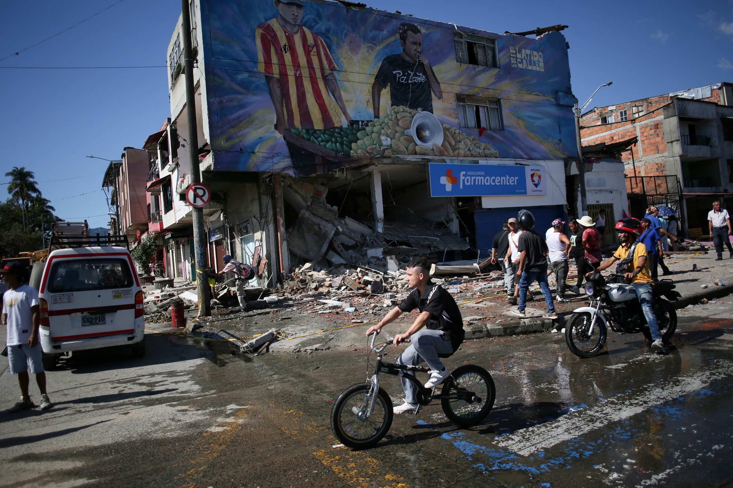 Una persona pasa en bicicleta junto a un edificio dañado tras un terremoto, en Pereira, Colombia, 10 de agosto, 2026. REUTERS/Juan David Duque