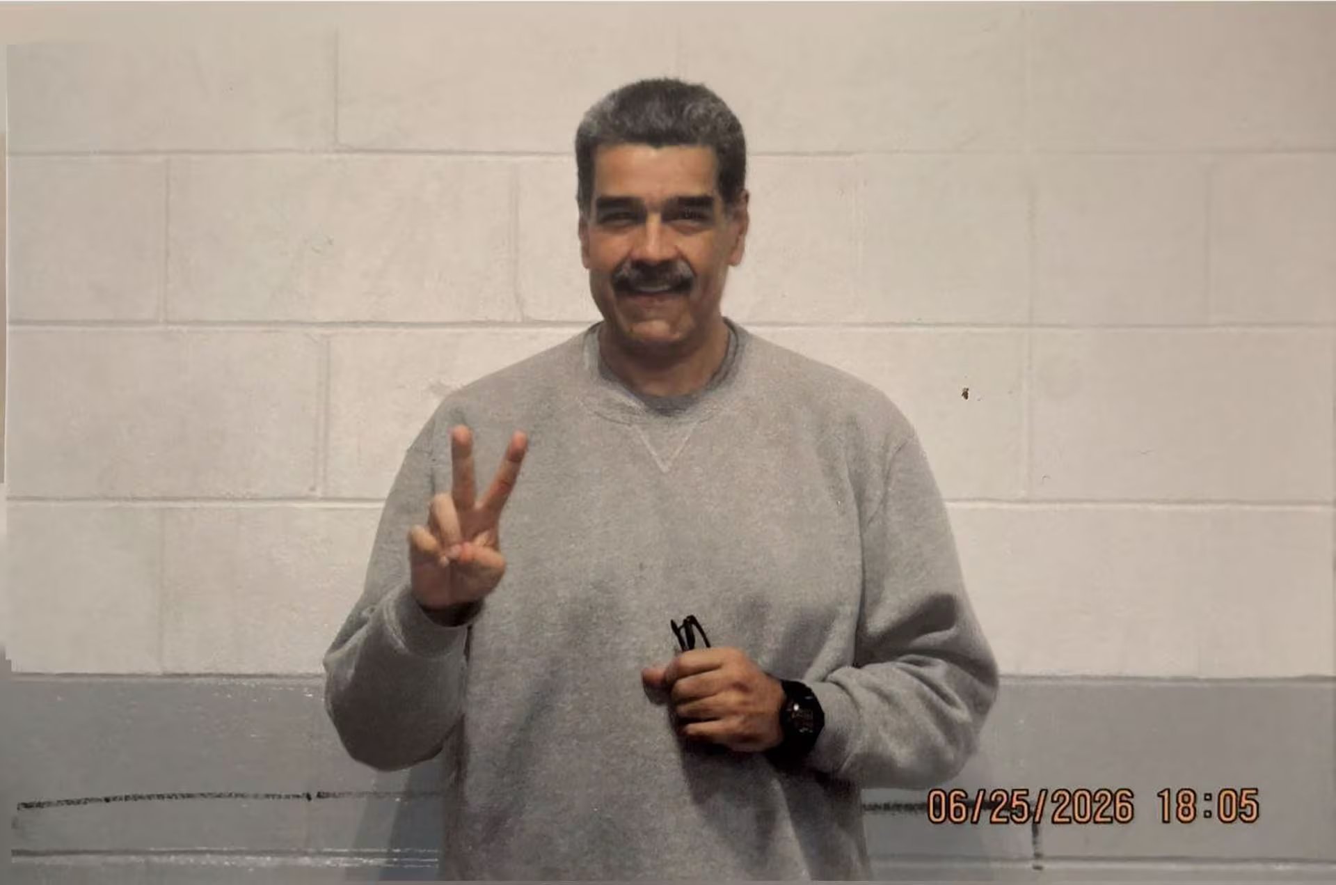 Nicolás Maduro posa frente a una pared de bloques mientras realiza el gesto de la victoria tras ser puesto bajo custodia en Estados Unidos.