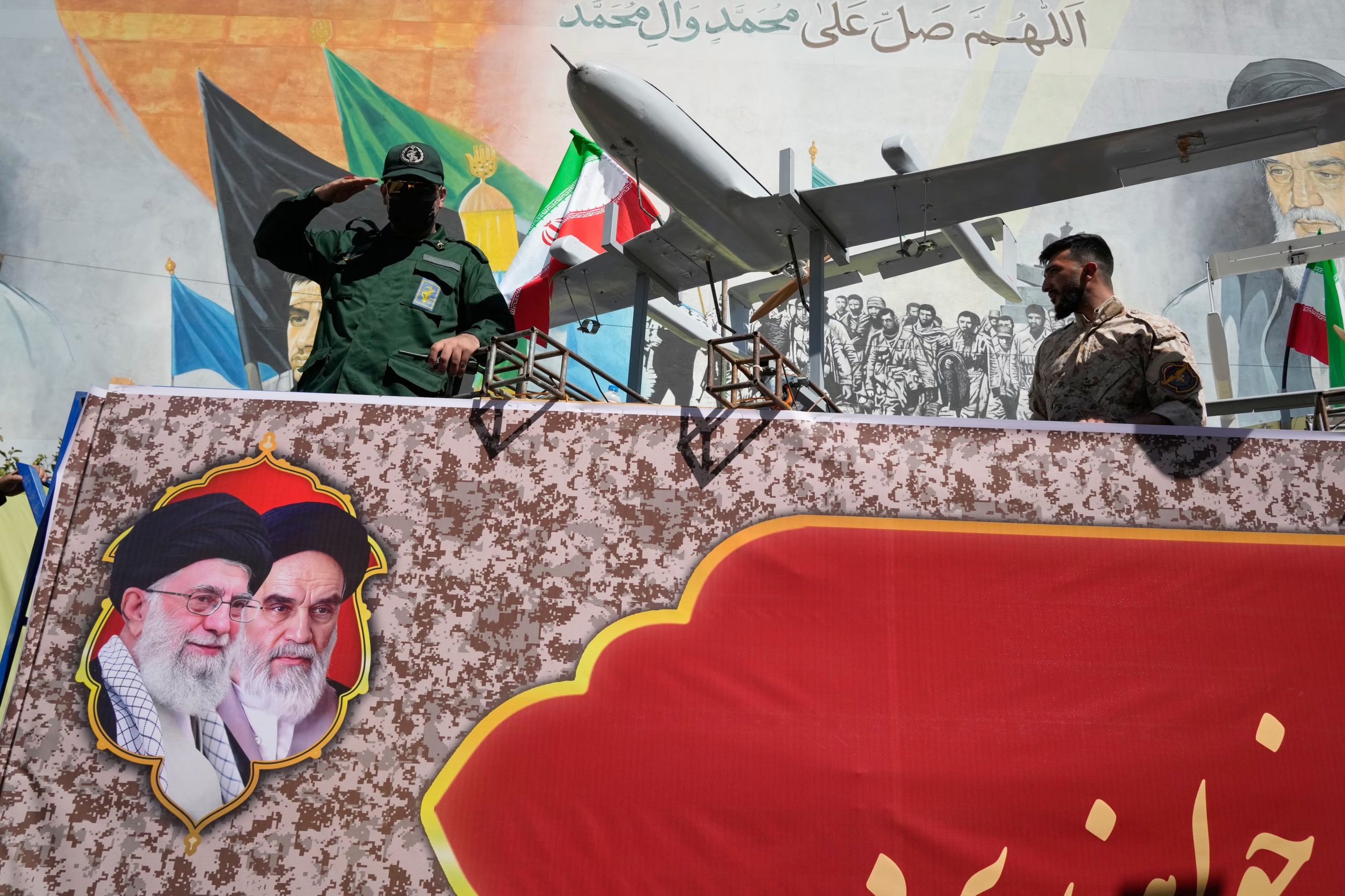 Un miembro de la Guardia Revolucionaria de Irán saluda a bordo de una carroza para exhibir drones durante el 