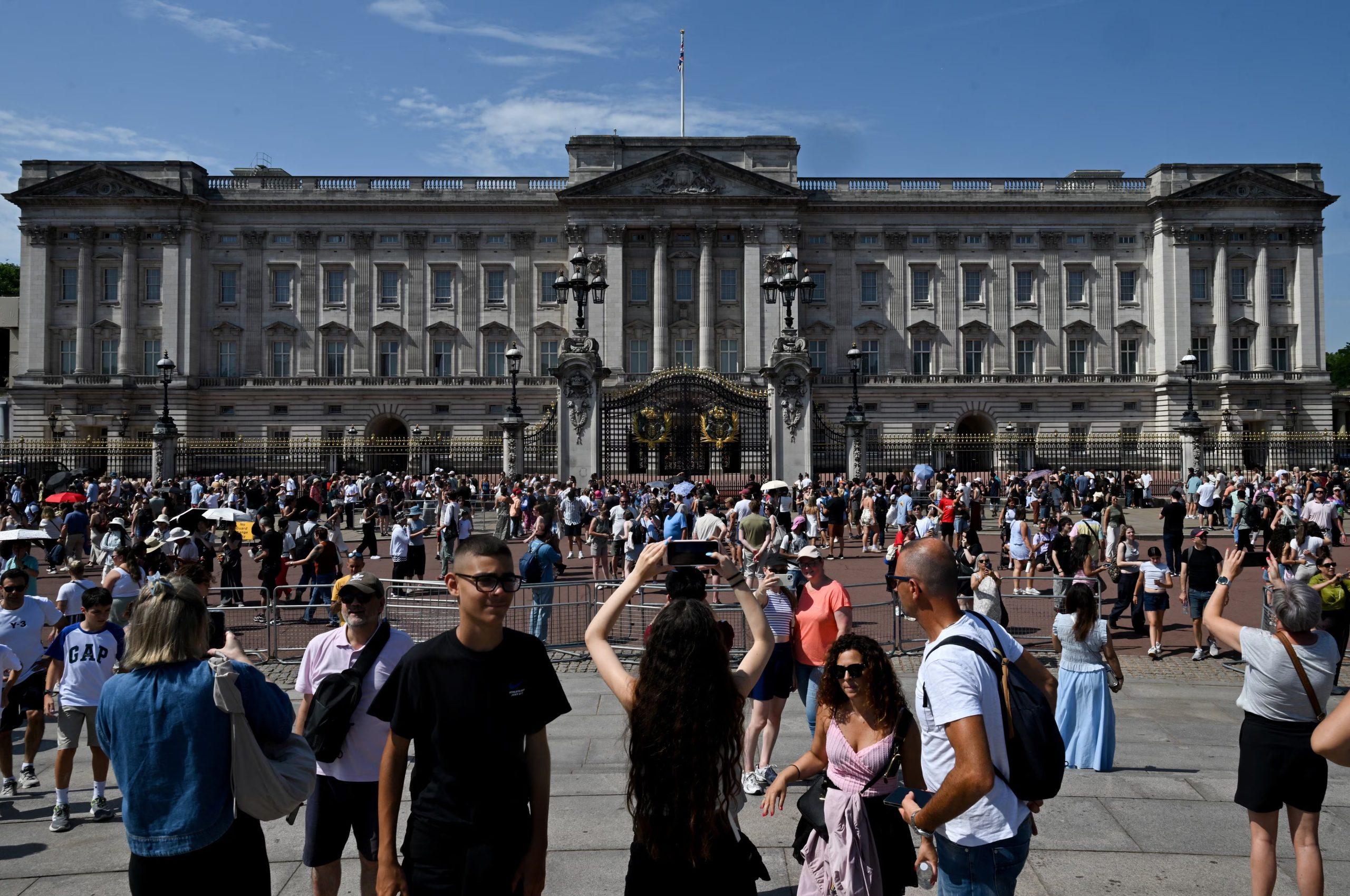 Varias personas se congregan frente al Palacio de Buckingham tras el anuncio de que el rey Carlos de Gran Bretaña no residirá allí una vez finalizada su remodelación de 10 años, que concluirá el próximo 26 de junio de 2026. (REUTERS/Jaimi Joy)