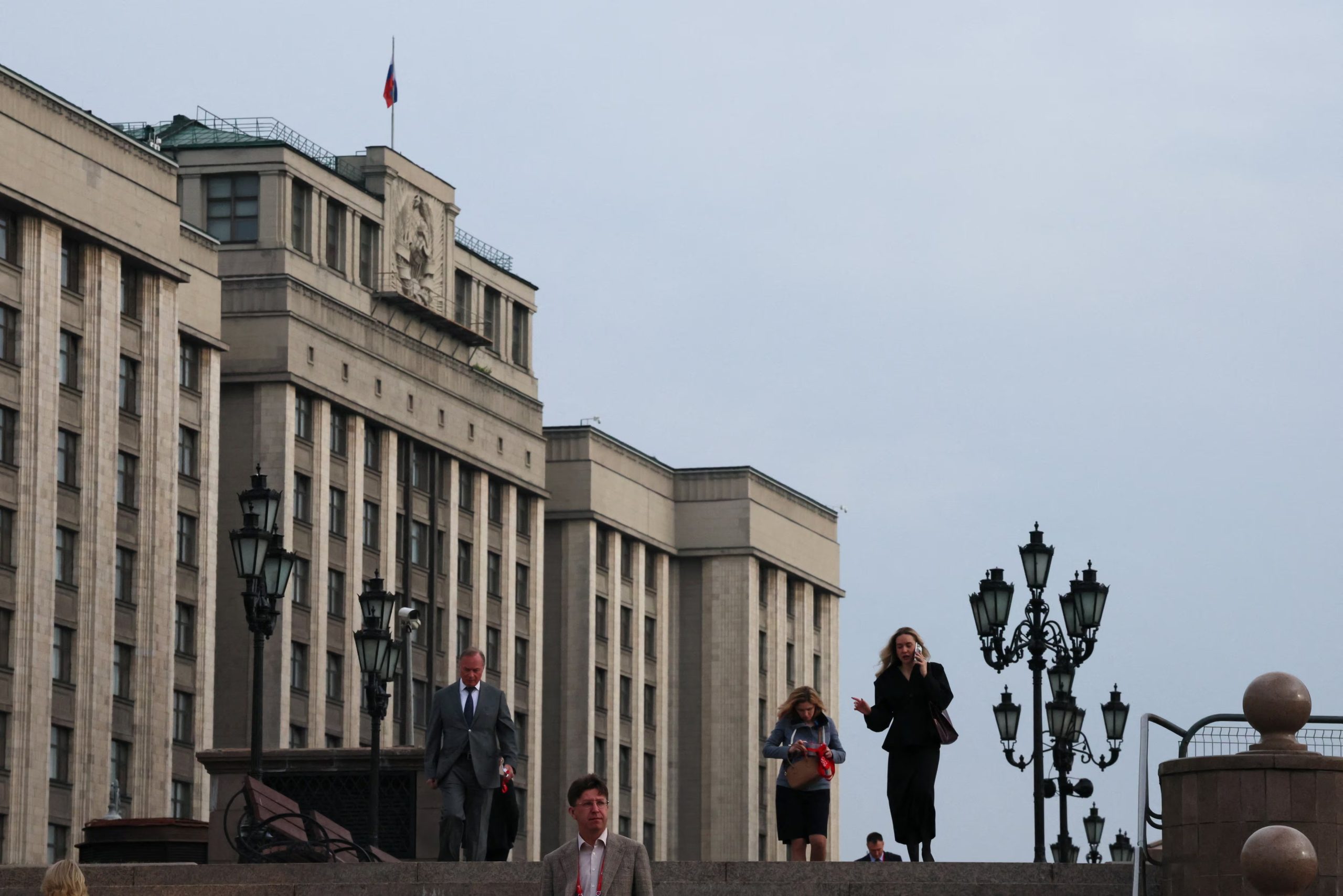 Transeúntes junto a la sede de la Duma en Moscú, la mañana después de una elección en la que Rusia Unida logró su mayor mayoría histórica. (REUTERS/Anastasia Barashkova)