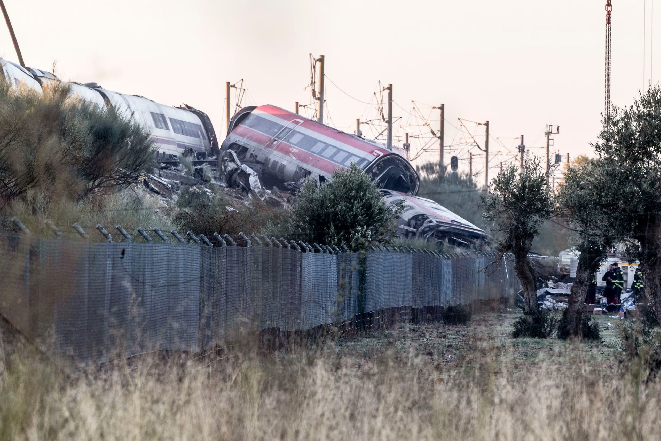 Los servicios de emergencia junto a maquinaria pesada trabajan en el lugar del accidente ferroviario un día después del suceso (EFE/ Ángeles Visdómine)