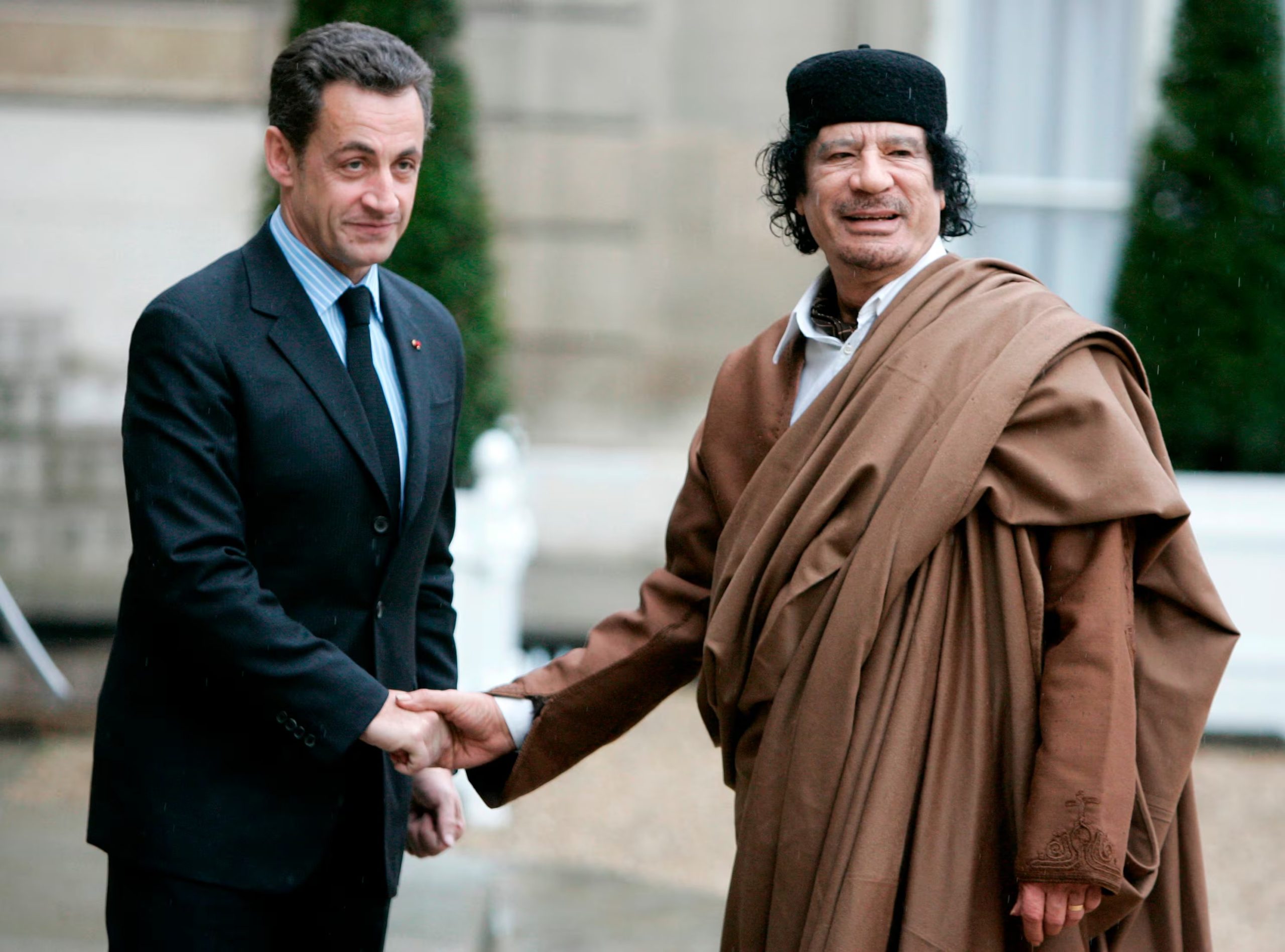 Diciembre de 2007. El presidente francés Nicolás Sarkozy, izquierda, saluda al líder libio Muamar Gadafi a su llegada al Palacio del Elíseo, en París (AP)