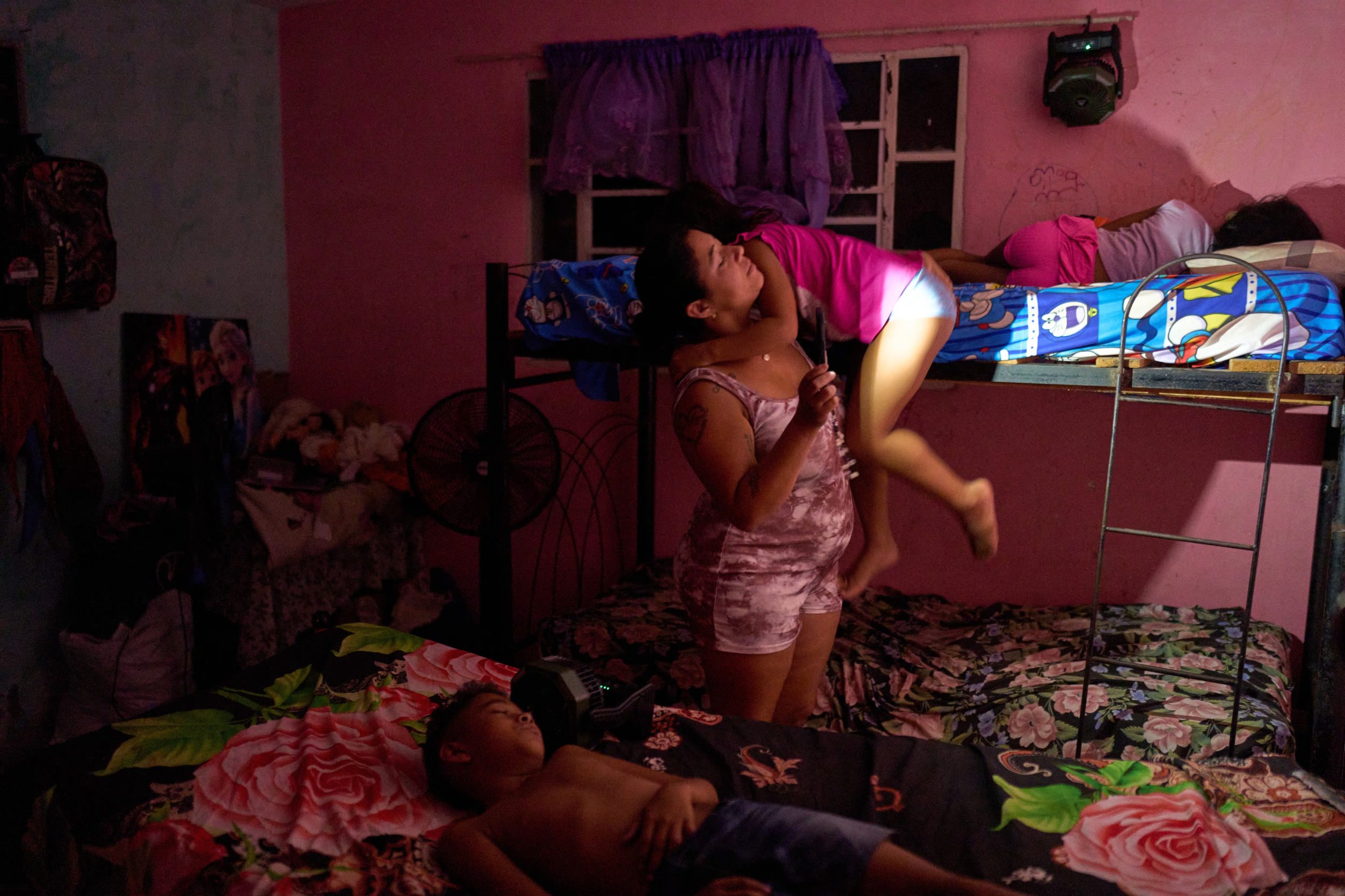 
Yurima Izaguirre utiliza la linterna de un teléfono móvil debido a un apagón mientras despierta a sus hijos para prepararlos para su primer día de regreso a clases en Minas, en la provincia de La Habana, Cuba, el martes 1 de septiembre de 2026. (Foto AP/Ramon Espinosa)