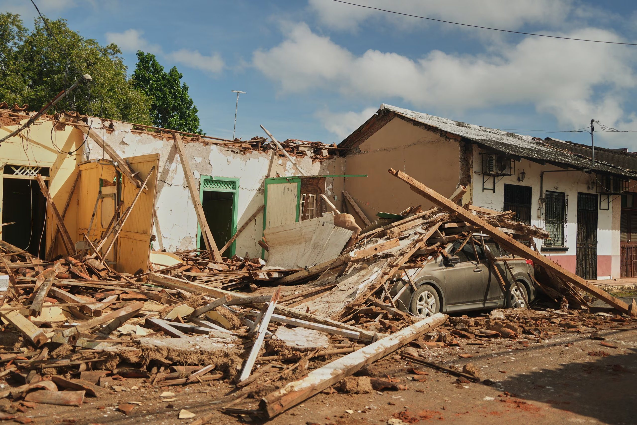 Un automóvil aparece cubierto de escombros de casas dañadas por un terremoto en Villa de los Santos, Panamá, el sábado 10 de octubre de 2026. (Foto AP/Aris Mariota)