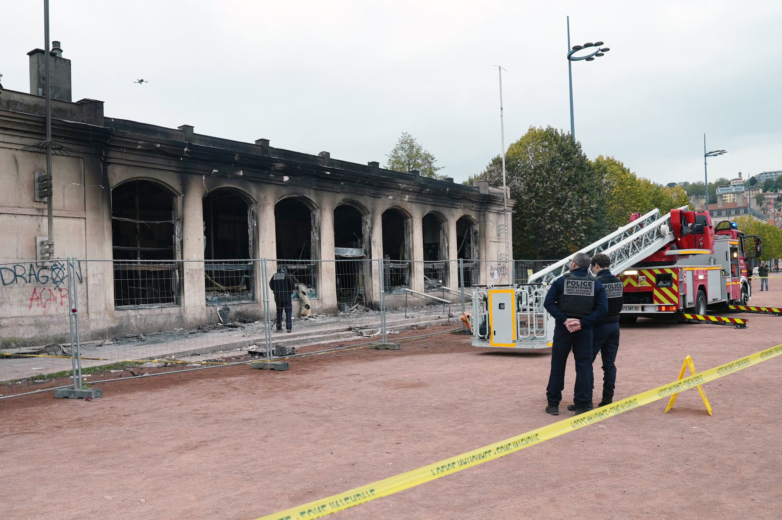 Policías franceses permanecen junto a un camión de bomberos estacionado frente a la oficina de turismo de Lyon, la cual fue vandalizada e incendiada durante los enfrentamientos que estallaron en una jornada nacional de manifestaciones contra el costo de vida y el aumento de los precios del combustible, en Lyon, Francia, el 19 de octubre de 2026. REUTERS/Cecile Mantovani