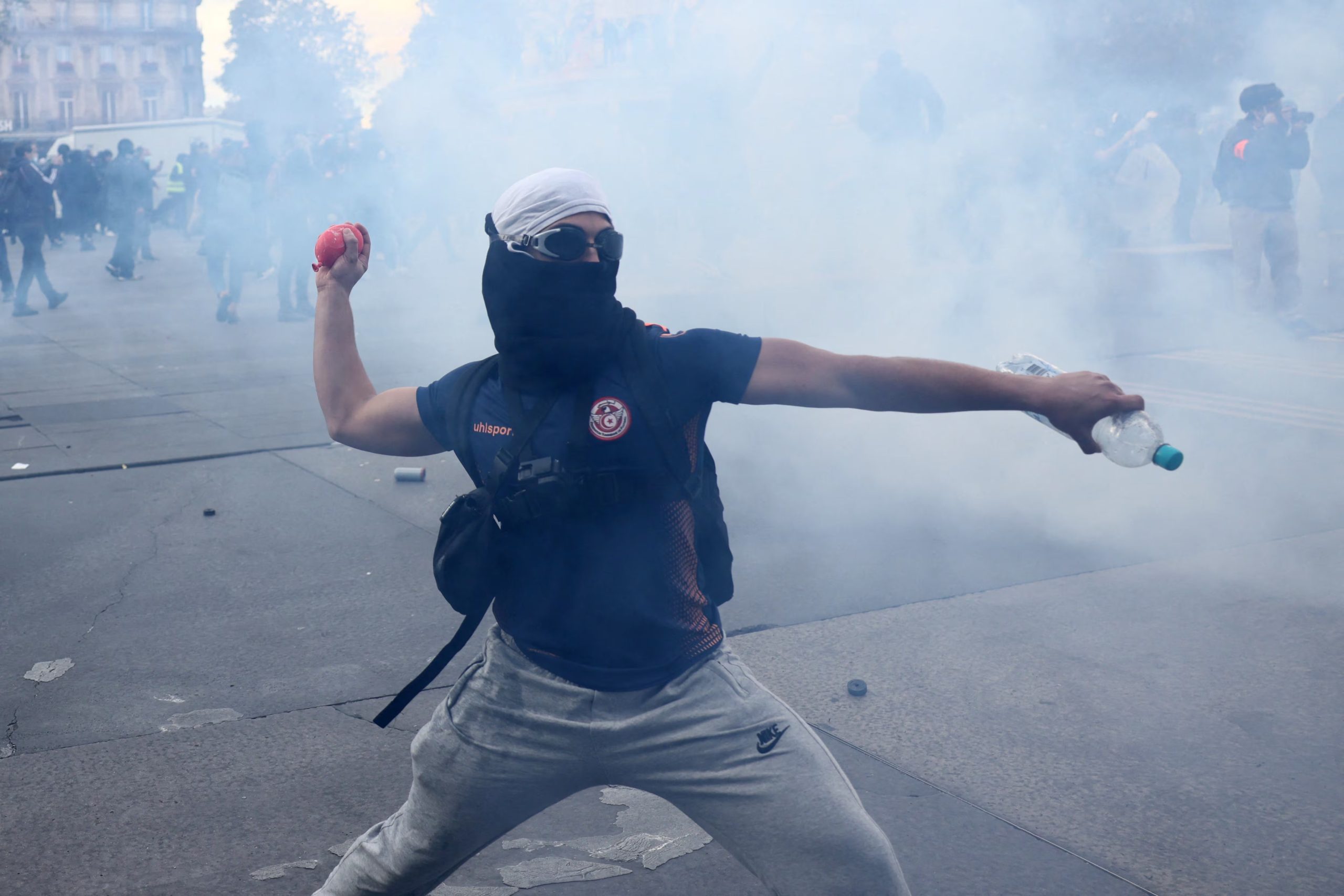 Un manifestante encapuchado lanza objetos contra la policía francesa (REUTERS/Jack Taylor)

