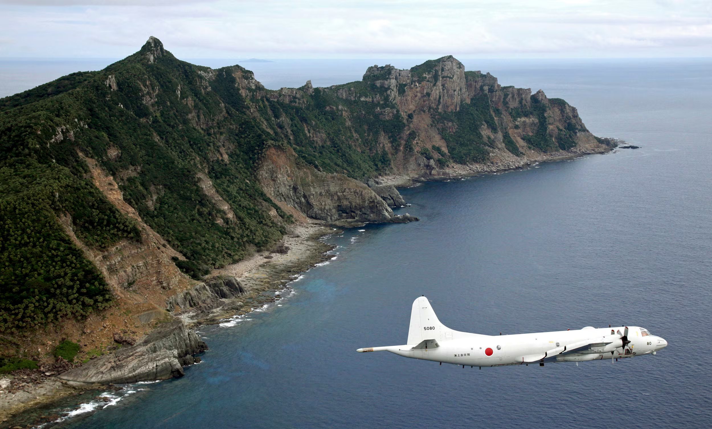 Un avión P-3C Orion de vigilancia de la Fuerza Marítima de Autodefensa de Japón vuela sobre las islas disputadas conocidas como Senkaku, el 13 de octubre de 2011 (AP, Archivo)