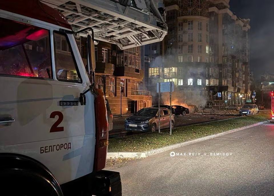 Un camión de bomberos y autos dañados frente a un edificio residencial atacado, según las autoridades, por drones ucranianos, en Belgorod. Dos de los tres muertos de la región fallecieron en la ciudad (Alcalde de Belgorod/vía REUTERS)