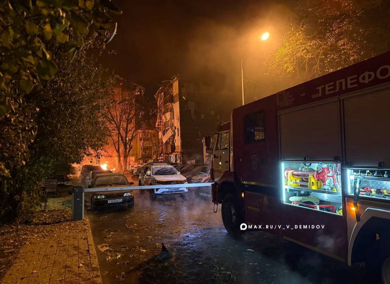 Un camión de bomberos y autos dañados frente a un edificio residencial atacado, según las autoridades, por drones ucranianos, en Belgorod. Hubo 14 heridos en la región (Alcalde de Belgorod/vía REUTERS)